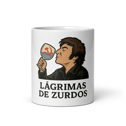 Mockup frontal de la Taza “Lágrimas de Zurdos”: ilustración estilo cómic de Javier Milei brindando con copa e icono comunista tachado, mug de cerámica blanca 330 ml libertario